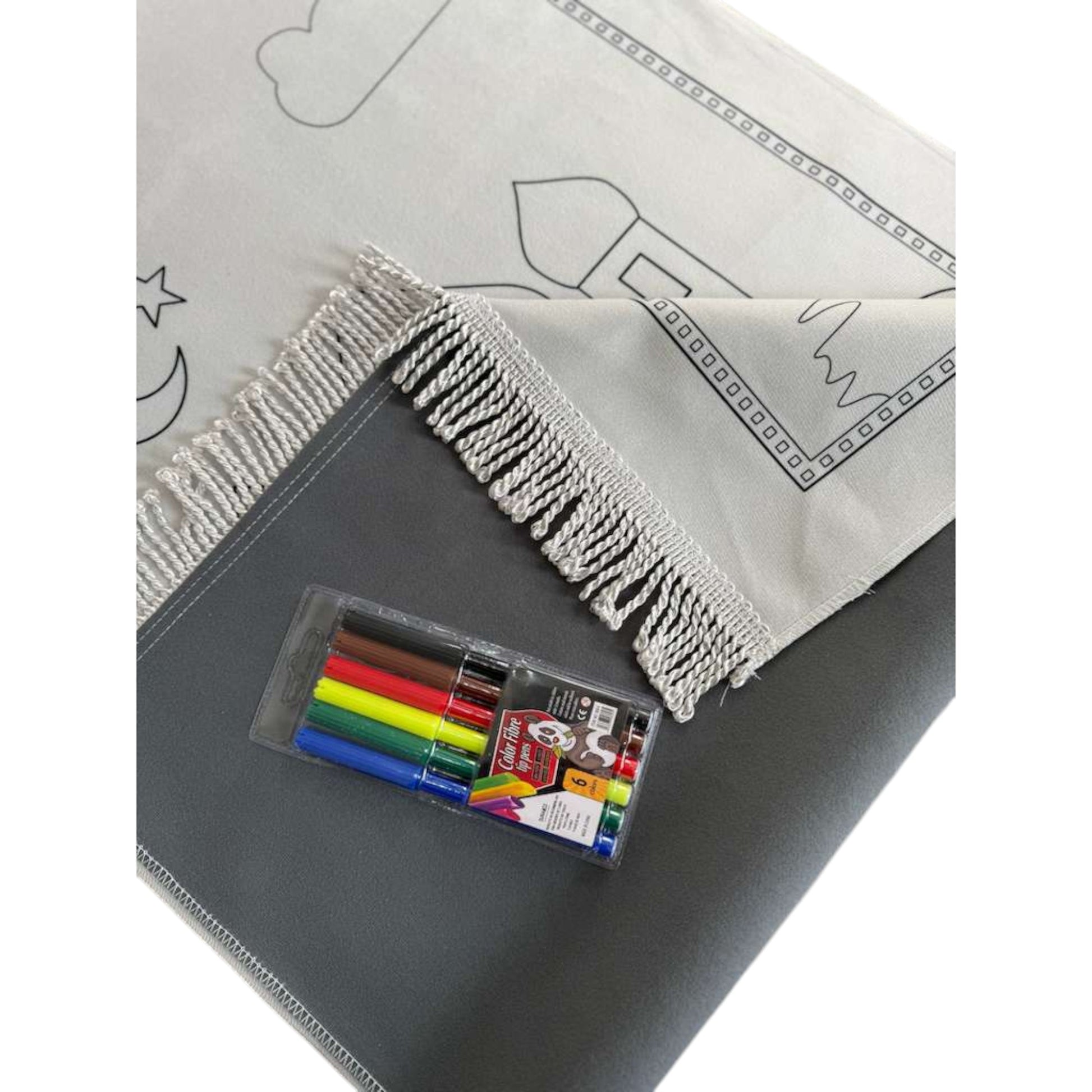 Coloring book with a set of markers on a gray surface