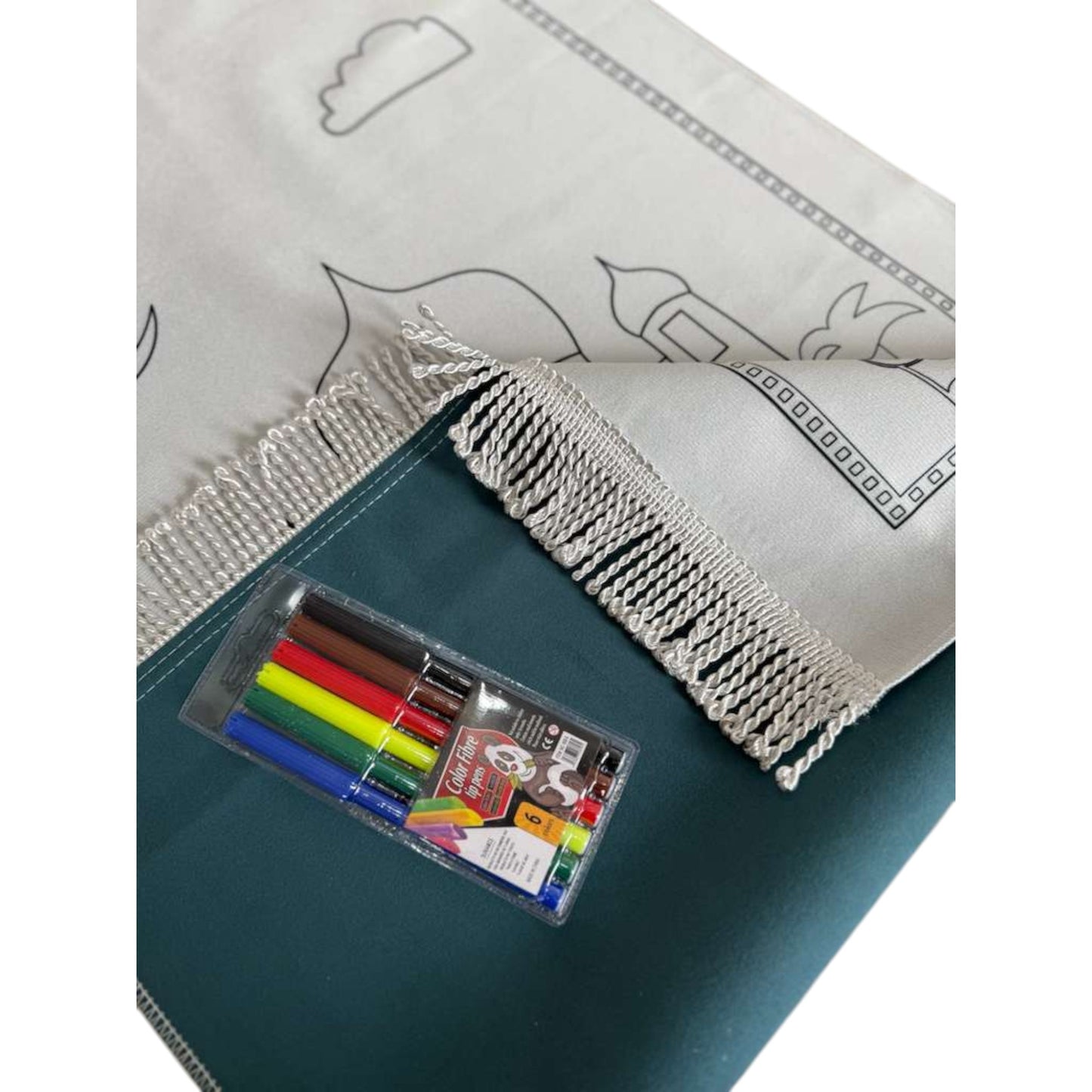 Coloring book with markers and a white cover featuring black line art on a green surface.