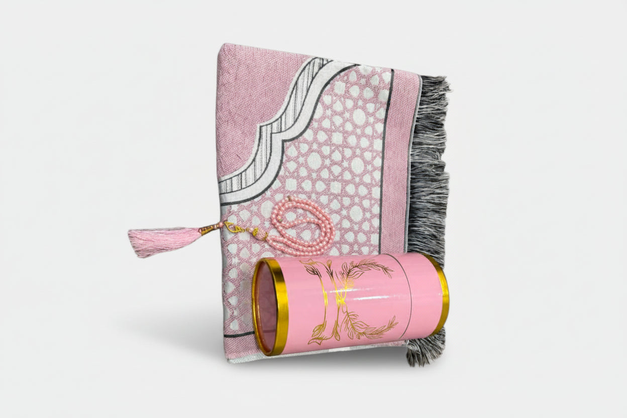 Pink patterned fabric with tassels and a cylindrical pink product with gold accents on a white background
